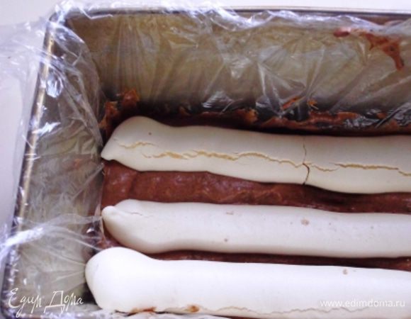 Форму выстелить пищевой плёнкой,  на дно выложить  немного крема, сверху разместить  палочки-меренги.  
