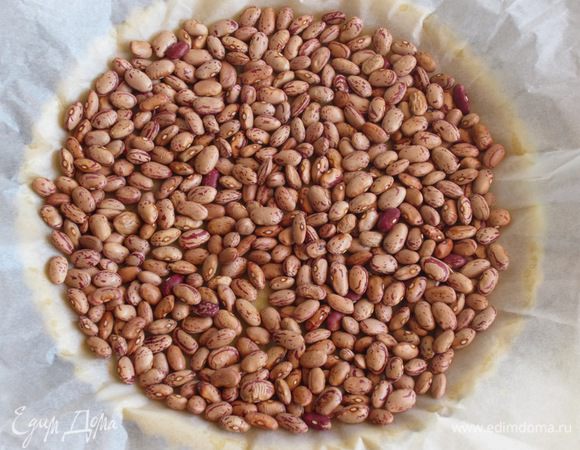 Сверху положить пергамент, насыпать фасоль и выпекать в разогретой до 180 ° С духовке 15 минут. Удалить пергамент с фасолью и выпекать ещё 5 минут. Остудить.