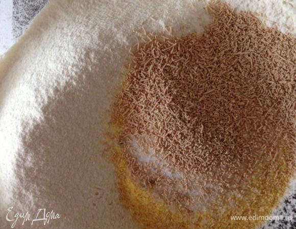 Для начала приготовим тесто. Смешаем в миске просеяную муку, кукурузную муку, соль, сахар и дрожжи. Добавим воду комнатной температуры и растительное масло. Хорошенько смешаем все ложкой, а затем замесим эластичное тесто. Я делала это вручную и процесс занял минут 5.