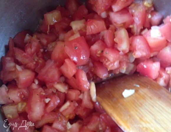 Добавим чеснок, помешаем секунд 30, чтобы чеснок отдал свой аромат и бросим в кастрюлю помидоры и сахар. Увеличим огонь до максимума, дадим смеси закипеть, снизим температуру и потомим наш соус минут 25-30 до готовности.