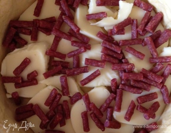 На тесто выкладываем моцареллу, затем колбаски.....