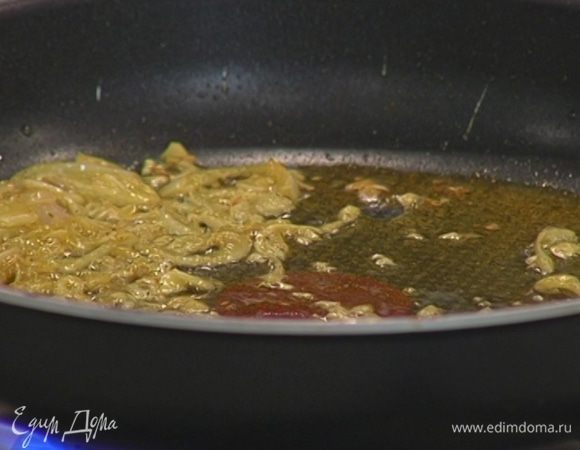 Чеснок почистить, мелко порубить и добавить в сковороду с луком, посыпать пудрой карри, все перемешать.