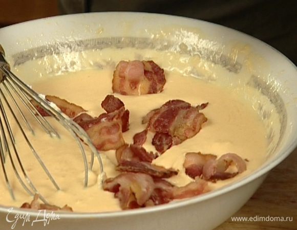 Половину сыра перемешать с яйцами, добавить сливки и бекон.