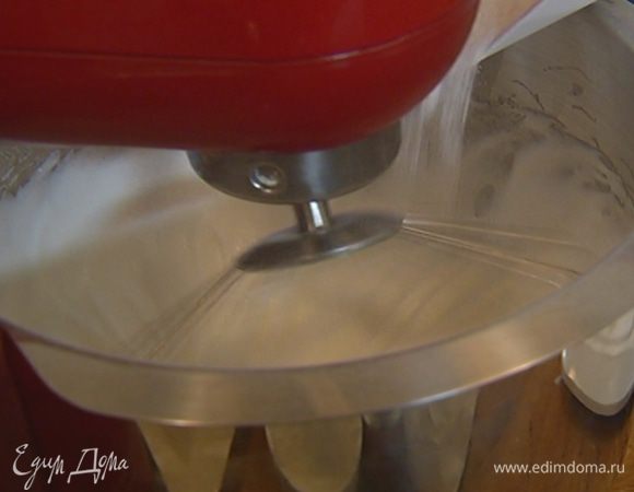 Сахар перемешать с крахмалом и, не прекращая взбивать белки, всыпать небольшими порциями в чашу комбайна.