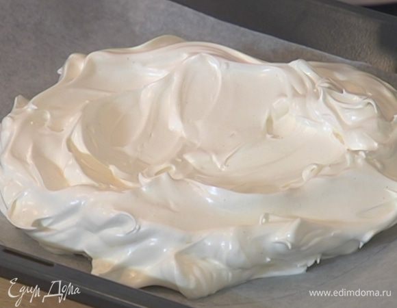 Противень выстелить бумагой для выпечки, начертить на бумаге круг (можно обвести тарелку) и выложить в него взбитые белки — края могут остаться неровными, а верх меренги должен быть довольно плоским и ровным.