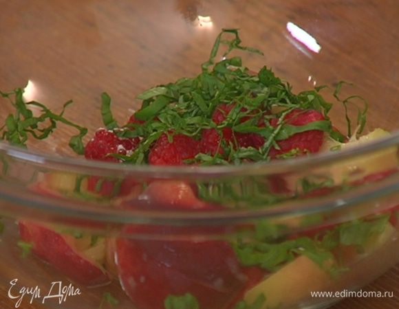 Листья базилика мелко порубить и посыпать персики с малиной.