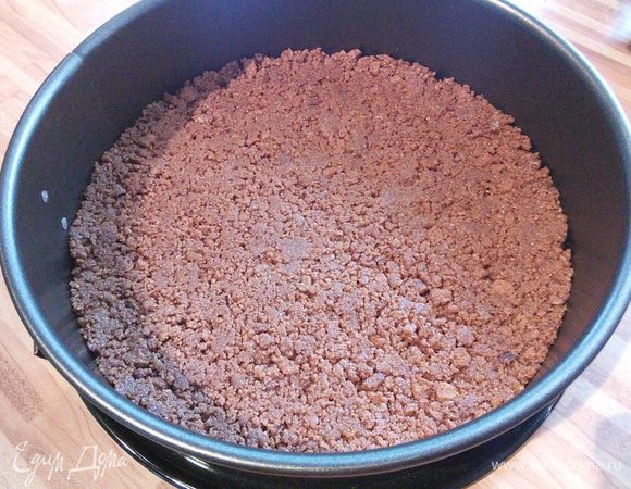 Распределите крошку по дну формы, утрамбуйте. Форму с основой поставьте в холодильник.