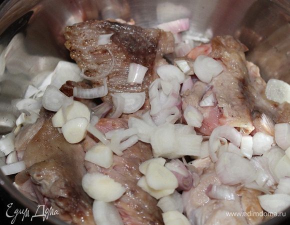 В кастрюлю сложить обжаренные крылья. Сверху посыпать крупно нарезанным луком. Залить водой, чтобы она покрывала крылья. Варить 40 минут.
