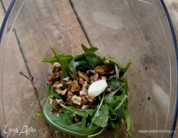Для песто: руколу промыть, обсушить, сложить в чашу блендера. Добавить грецкие орехи (предварительно обжарив на сухой сковороде), зубчик чеснока, соль и перец по вкусу.