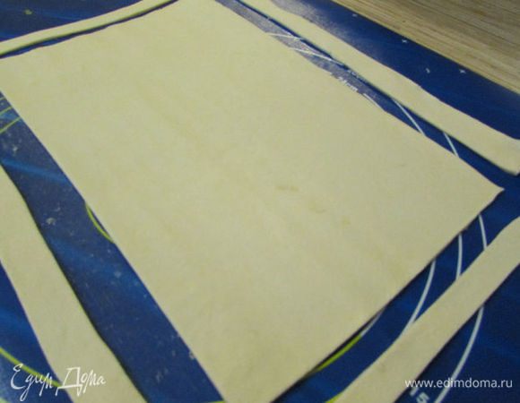 Тесто разморозить, раскатать так, чтобы получился прямоугольник 20×30. Обрезать края. Получилось прямоугольное тесто и 4 обрезанных полоски. 