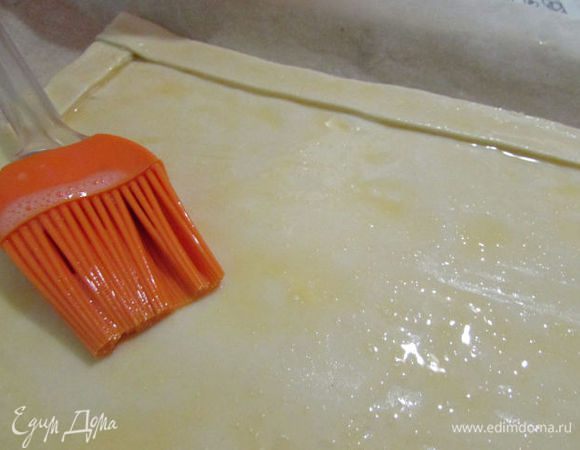 Полоски теста уложить на прямоугольник, формируя бортики. Смазать всё яйцом. 