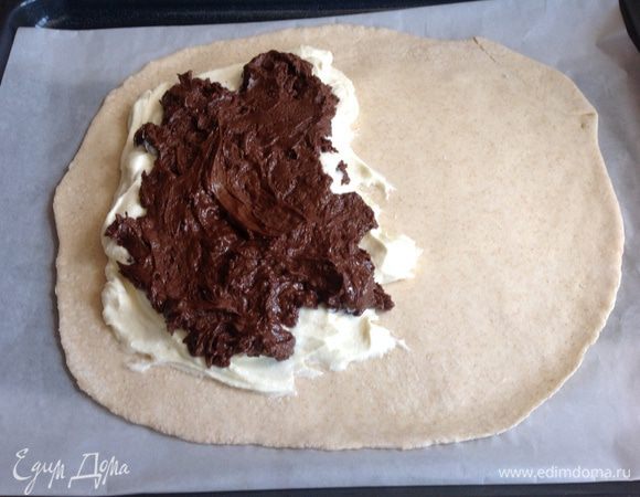 Духовку разогрейте до 230 градусов. Выложите на тесто сырную смесь, затем шоколадную ближе к одному краю. Смажьте края лепешки желтком взбитым с 1 ст л холодной воды и защепите, формируя полукруг.