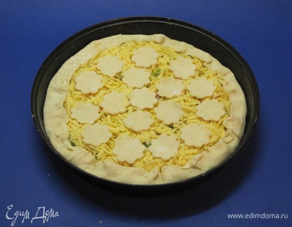 Из оставшегося теста вырезать фигурные кружочки. Выложить на тертый сыр.