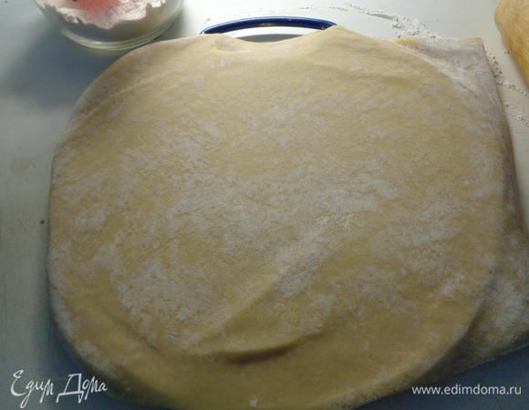 Достать из холодильника песочное тесто и раскатать его, на присыпанной мукой поверхности, в круг.