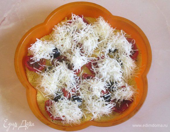 Готовую горячую поленту распределите по силиконовым формам или на противень. У меня получилось две такие формы, как на фото. Разложите на поверхности поленты вяленые помидоры, половинки маслин, посыпьте сухими итальянскими травами. Сыры натрите и порциями укройте поверхность кукурузной поленты. Поместите в разогретую до 200 градусов духовку и нагрейте до расплавления сыра.