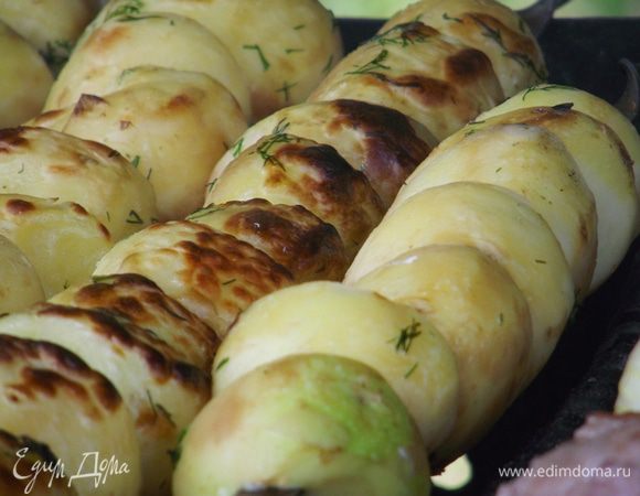 Периодически смазываем картофель маринадом и не забываем переворачивать! Любой крышкой от формы "обдуваем" картофель, чтобы угольки не угасали и держали равномерную температуру. 