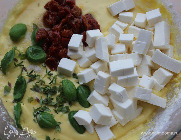 Фетаксу нарезать мелким кубиком, помидоры измельчить. Оборвать листики с тимьяна и базилика. Положить в тесто и аккуратно перемешать снизу вверх.