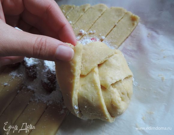 
Теперь полоски теста выкладываем на начинку по одной с каждой стороны пласта, заплетая косичку.