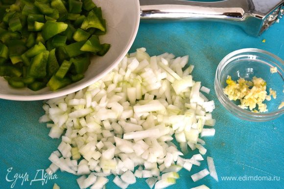 Сладкий зеленый перец очистить от семян и мелко нарезать. Помельче нарезать лук и выдавить (измельчить) чеснок.