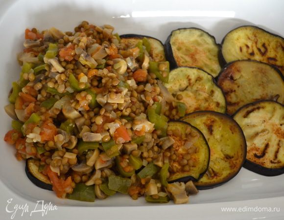 Половину жаренных баклажанов положить на дно широкого огнеупорного блюда для запекания. Сверху равномерно выложить чечевичную смесь. Затем еще один слой баклажанов. На время отставить.