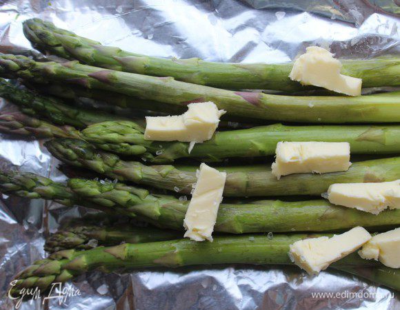 Вторую часть спаржи выложить на лист фольги, посыпать крупной морской солью, выложить сверху кусочки сливочного масла. Сложить фольгу конвертом и запекать 10 минут при Т 200 градусов.