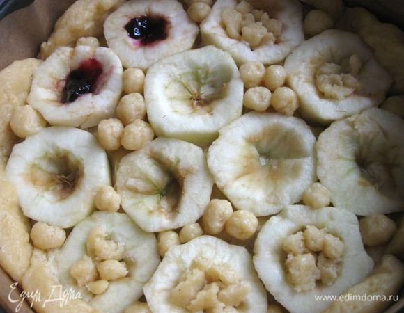 Заполнить частично джемом ( немного, чтобы не растекался во время выпечки, остальную часть дополнить позднее), некоторые из яблок наполняла джемом после смазывания теста яйцом, частично заполнить кусочками теста, придав им форму лепестков. Промежутки между яблоками заполнить небольшими шариками из теста. Отправить в духовку, разогретую до 200 градусов на 40 - 45  минут до румяного цвета  выпечки. Вам может понадобиться чуть меньше или больше времени. 

