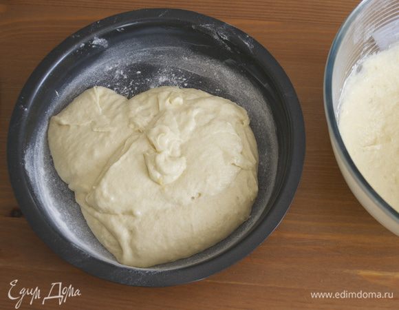 Распределить тесто поровну в две формы (диаметром 24 см), предварительно смазанные жиром и присыпанные мукой. 