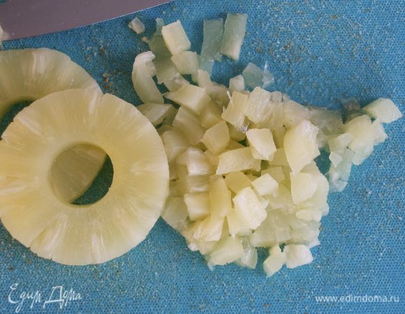 Консервированный ананас достать из банки и дать полностью стечь соку сиропу. Нарезать ананас на маленькие кубики. 