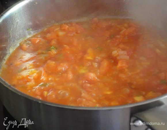 3. Лук и чеснок очистить, мелко нарезать. Перчик чили (у меня зеленый, не нашла красный) очистить от семян и измельчить. На другой сковороде разогреть оставшееся масло, обжарить лук и чеснок до мягкости, добавить чили.
4. Если у вас консервированные помидоры, то их надо размять вилской и выложить в сковороду вместе с соком. Я решила использовать свежие помидоры - 2 больших, примерно 600 г. Очистила их от кожицы (с помощью кипятка) и нарезала мелкими кубиками и добавила 2 ст. ложки острого томатного соуса. Помидоры добавить к луку и тушить 3 минуты.