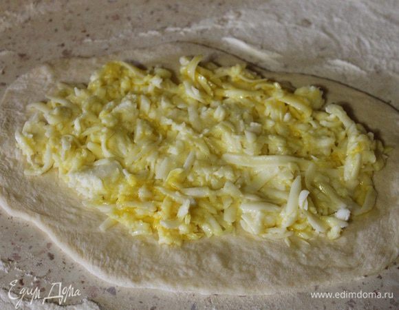 Тесто разделить на 7 равных частей, раскатать скалкой в пласты, придав форму больших овалов. На каждый овал выложить равное количество начинки, оставив свободными края.