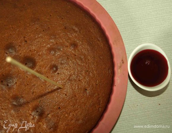 Готовый пирог достать, теплым наколоть по всей поверхности пирога бамбуковой шпажкой и пропитать вишневым сиропом. 