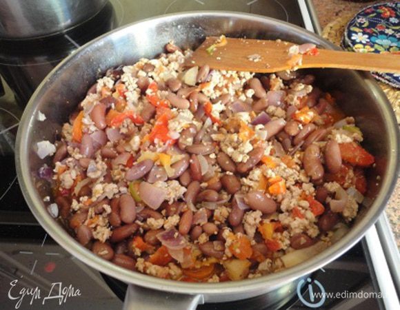 В сковороду влить бульон, посолить, поперчить, добавить орегано, кумин, а также фасоль. Закрыть крышкой, убавить огонь до слабого и тушить около 15-20 минут.
За 2-3 минуты до готовности добавить чеснок. Подавать горячим.