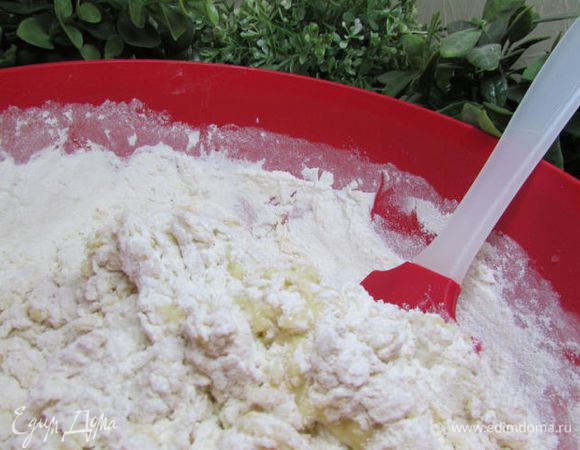 Всыпьте муку и вымесите тесто, пока оно не станет гладким и не перестанет липнуть к рукам.