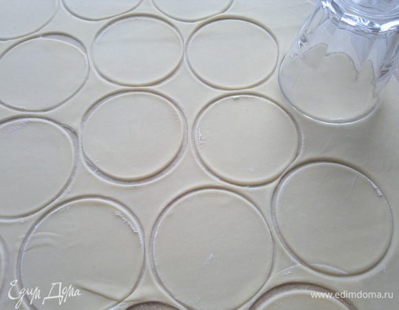 Тесто раскатываем толщиной 3 мм и вырезаем кружки любой формой. 
У меня стакан и чашка служили такой формой, нижняя вареница была меньше в диаметре от верхней(так было удобнее лепить вареники).