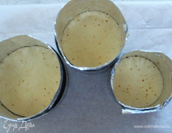 Я собирала тортики в вырубках, предварительно сделав в них бортики из фольги. На дно каждой формы положить бисквитное кольцо