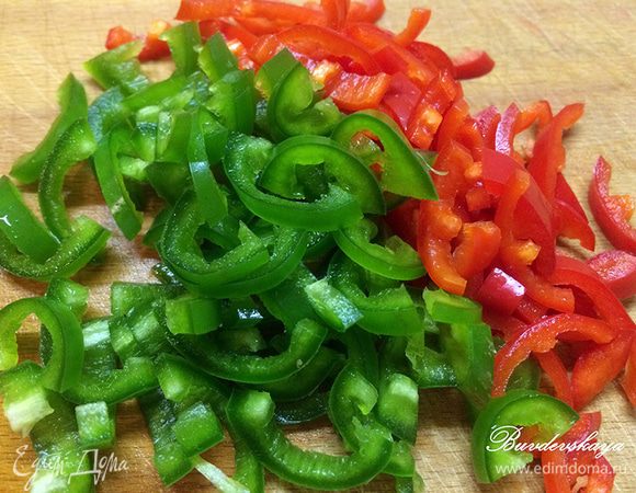 Перцы Чили вымойте, обсушите, разрежьте вдоль на две части, освободите от семян и нарежьте наискосок на небольшие ломтики. Добавьте их в сковороду.