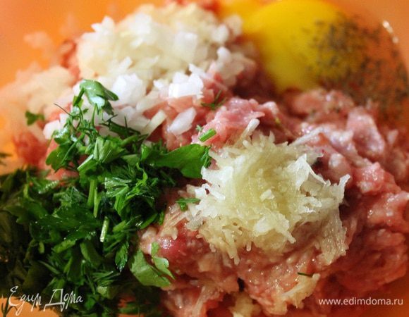 Займемся фаршем. У меня фарш из куриных бедрышек с кожей. Лук режем мелким кубиком, чеснок потереть на мелкой терке, петрушку и укроп мелко порубить. Все это кладем в фарш, добавляем яйцо, соль и перец, хорошо все  перемешиваем.