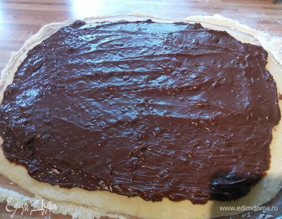 Тесто раскатайте на посыпанной мукой поверхности в прямоугольник. Выложите пудинг.