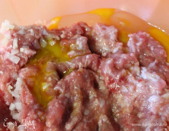 В фарш добавляем яйцо, чеснок пропущенный через пресс, лук, соль и перец по вкусу. Тщательно все перемешиваем.