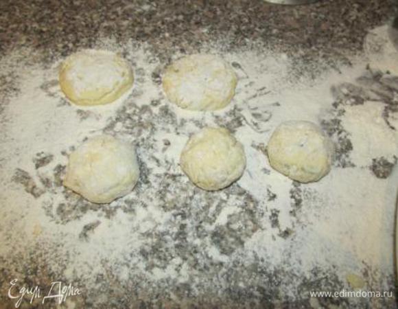 Из полученной массы лепим небольшие шарики по 35-40 грамм. Панируем в муке (оставшиеся 100 грамм). Затем шарики немного приплюскиваем, придавая форму сырников. Из исходных ингредиентов получается примерно 14-15 штук.