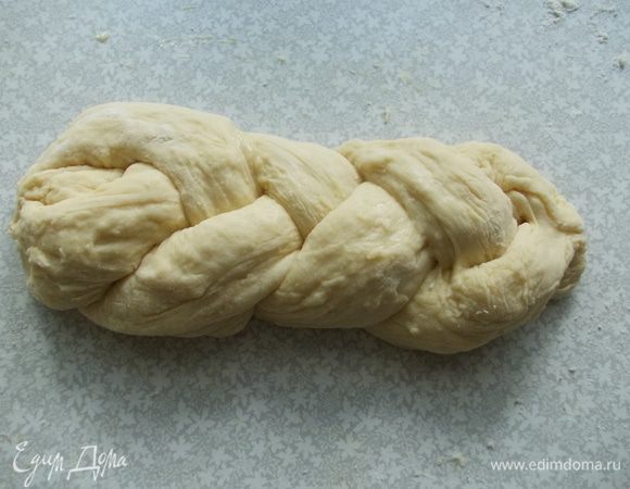 Плетем косичку из теста. Делаем то же самое с другой частью. Выкладываем на противень, заранее выстелите его бумагой и посыпьте мукой. Накройте полотенцем и поставьте в теплое место еще на 30 мин. 