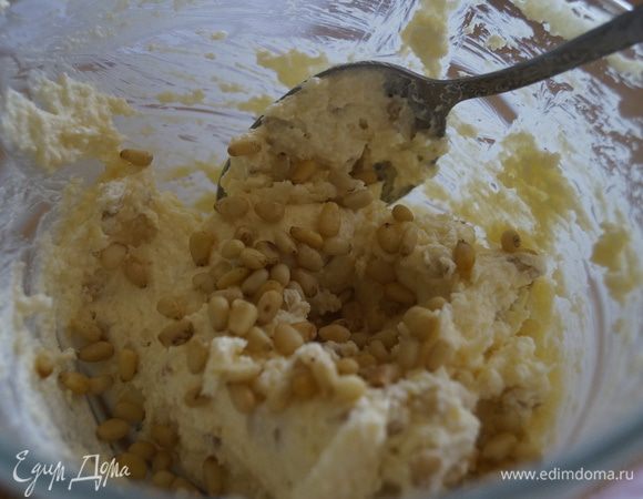 Добавить кедровые орешки и перемешать так, чтобы они распределились по всему тесту.