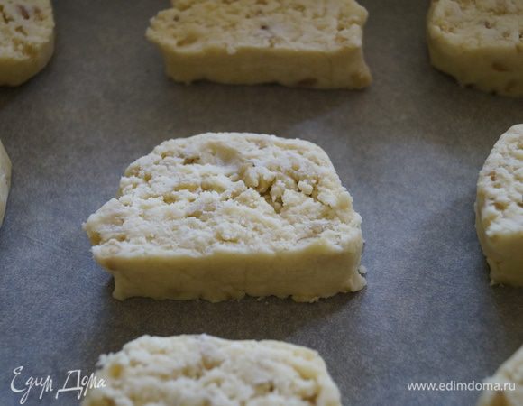 Охлажденную колбаску нарезать ломтиками толщиной не более 1 см. Выложить на противень застеленный бумагой для выпечки.