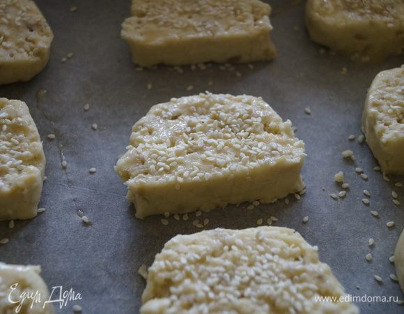 Смазать печенье взбитым яйцом, посыпать кунжутом и поставить в разогретую до 180 градусов духовку. Выпекать 15 минут. 