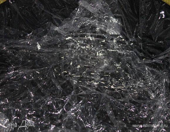 Форму застелить пищевой пленкой так, чтобы свисали края.