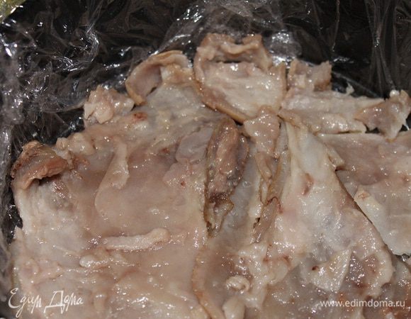 Остуженное до теплого состояния мясо можно укладывать в форму. Сначала снимаем с рульки кожу, срезаем лишний жир и укладываем в форму.