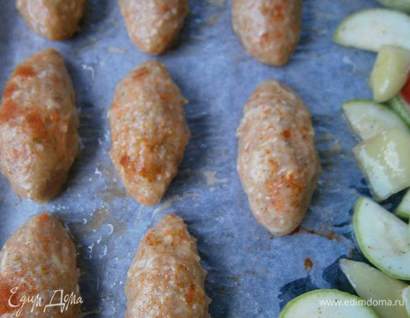 Противень застелить бумагой для выпечки, смазать растительным маслом и выложить подготовленные котлеты,  и слегка  присыпать паприкой  (рядом, я ещё положила нарезанный кабачок, сладкий перец, помидор - для гарнира).
