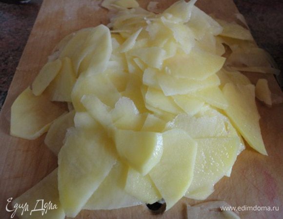 1. Картофель очистить и замочить в воде на 30 минут, чтобы вышел крахмал, и нарезать тонкими пластинками. Я делала это на терке. Пластинки получаются почти прозрачными.
