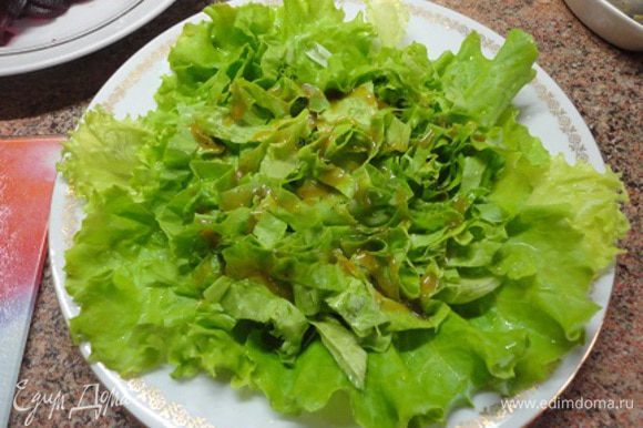 Для этого салата подойдет любой листовой салат, дело вкуса. Выложите на тарелку часть салата, полейте немного заправкой.