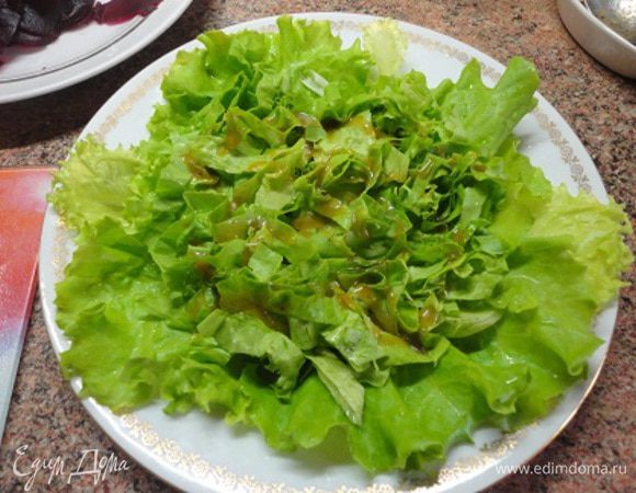 Для этого салата подойдет любой листовой салат, дело вкуса. Выложите на тарелку часть салата, полейте немного заправкой.
